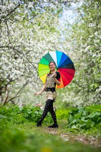 Värikäs sateenvarjo valkoisten kukkien keskellä.