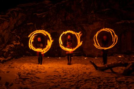 Kolmen vanteen muodostamat tuliympyrät kallionseinämää vasten.